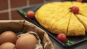 A kitchen counter with a loaf of bread, eggs, and tomatoes.