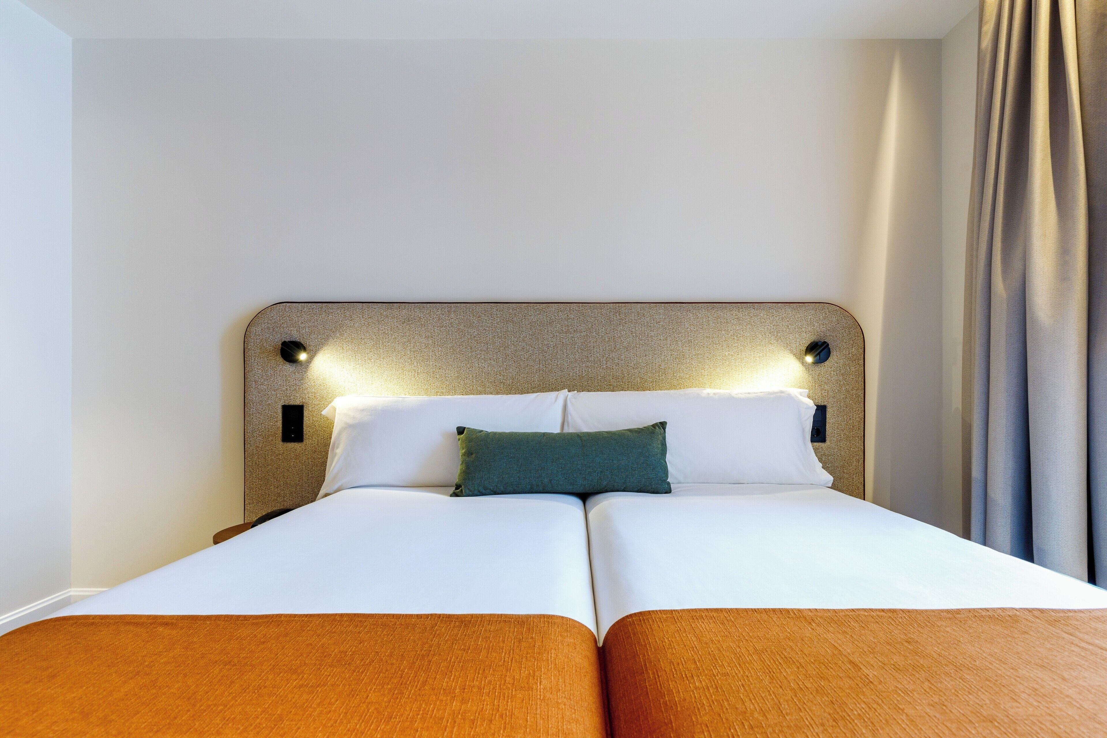 A double bed with a headboard, two pillows, and a bedside table.