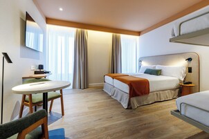 Una camera d'albergo con un letto, una scrivania e una sedia.