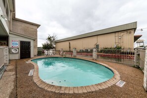 Piscina con borde de ladrillo, escalera de piscina y señal que indica prohibido bucear.