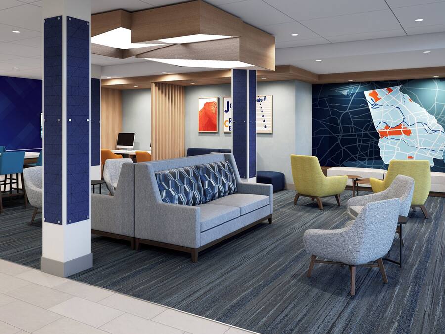 A modern lobby with seating areas, a reception desk, and a large map mural on the wall.