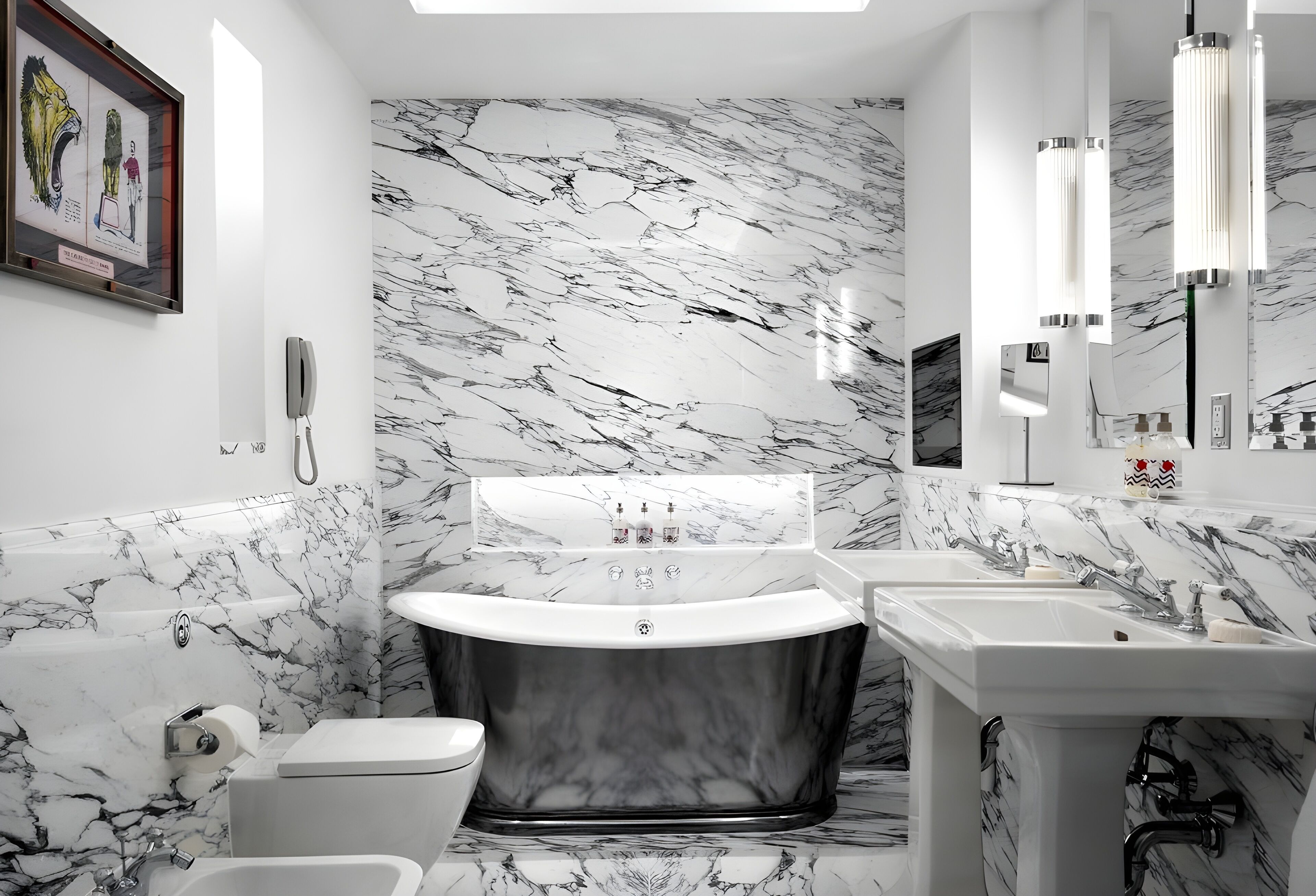 A bathroom with a marble wall, a freestanding bathtub, a toilet, and a sink with a mirror.