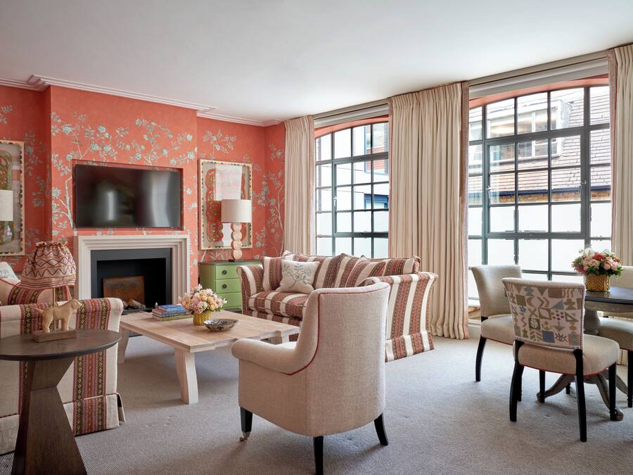A living room with a sofa set, a coffee table, a fireplace, and a television.