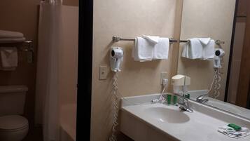 A bathroom with a white sink, a mirror, a hairdryer, and a shower curtain.