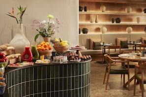 A buffet setup with various food items and a decorative plant arrangement. - Tivoli la Caleta Resort (Adeje)