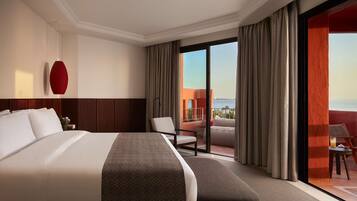 A hotel room with a large bed, a chair, a small table with a drink, and a balcony with curtains.