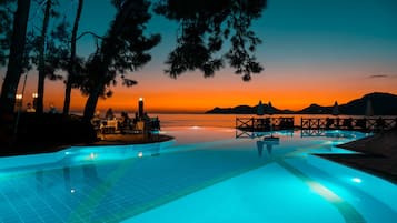 Relax by the pool surrounded by trees and distant mountains.