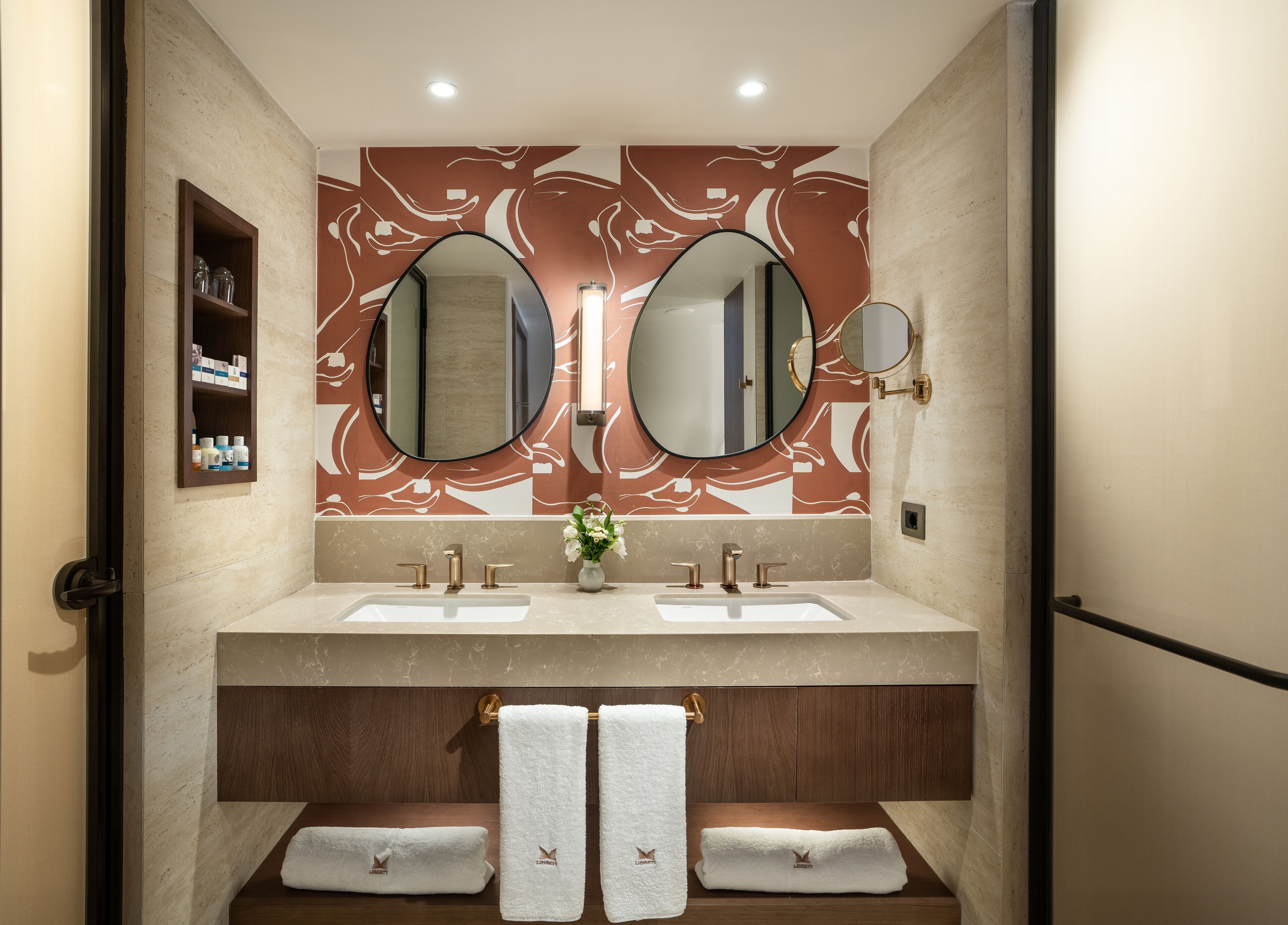 A bathroom with two sinks, a mirror, and a towel rack.