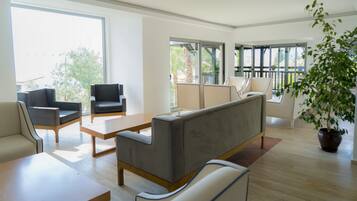 A modern living room with a sofa, armchairs, and a coffee table.