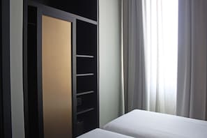 A hotel room with a bed, a wardrobe with a mirror, and a window with curtains. - c-hotels Diplomat (Florence)