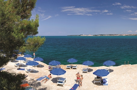 Plage à proximité, chaises longues, parasols, beach-volley. Lanterna Resort