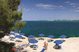 Una playa cerca, sillas reclinables de playa, sombrillas