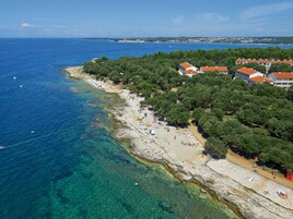 Una playa cerca, sillas reclinables de playa, sombrillas