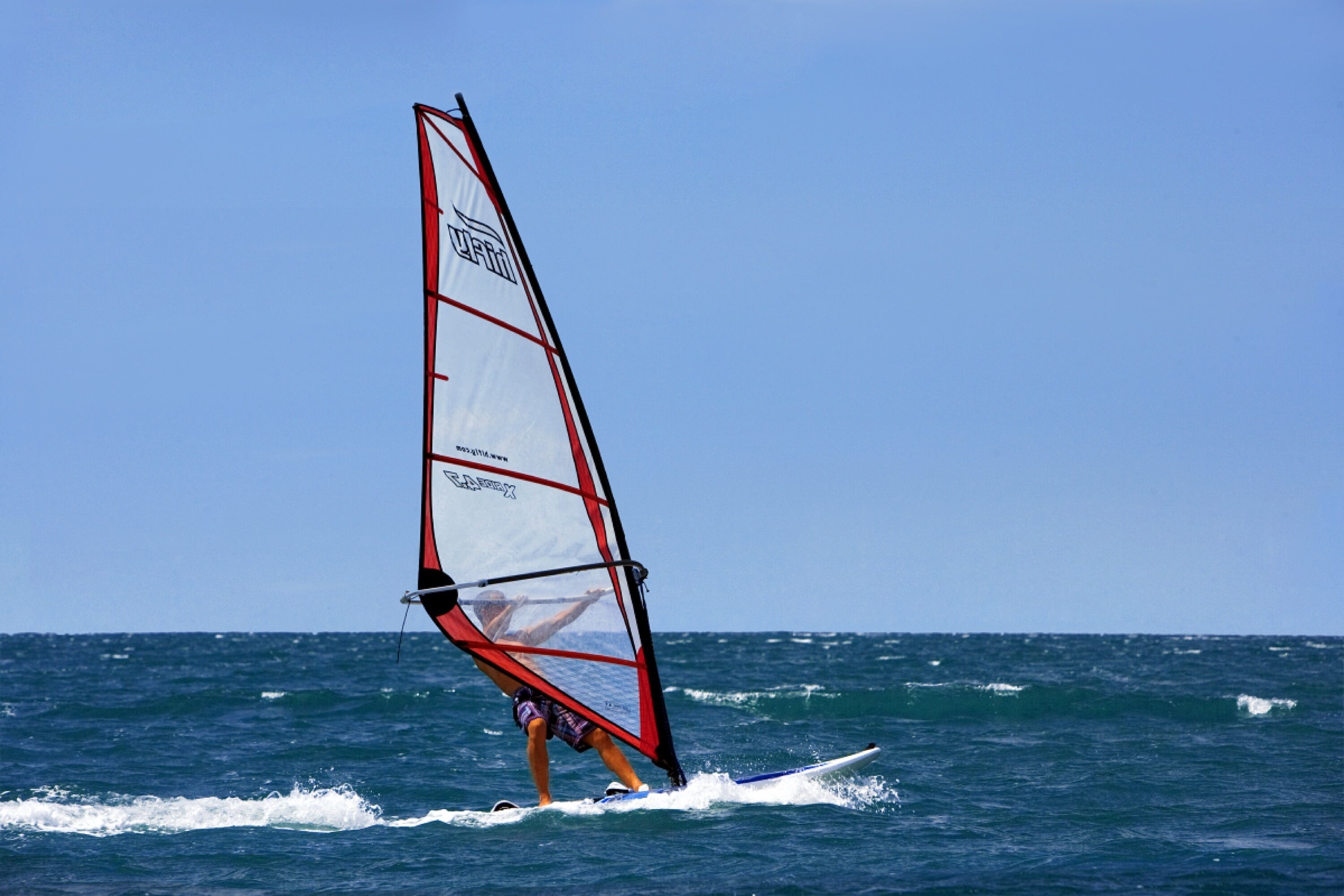 A person windsurfing on the ocean.