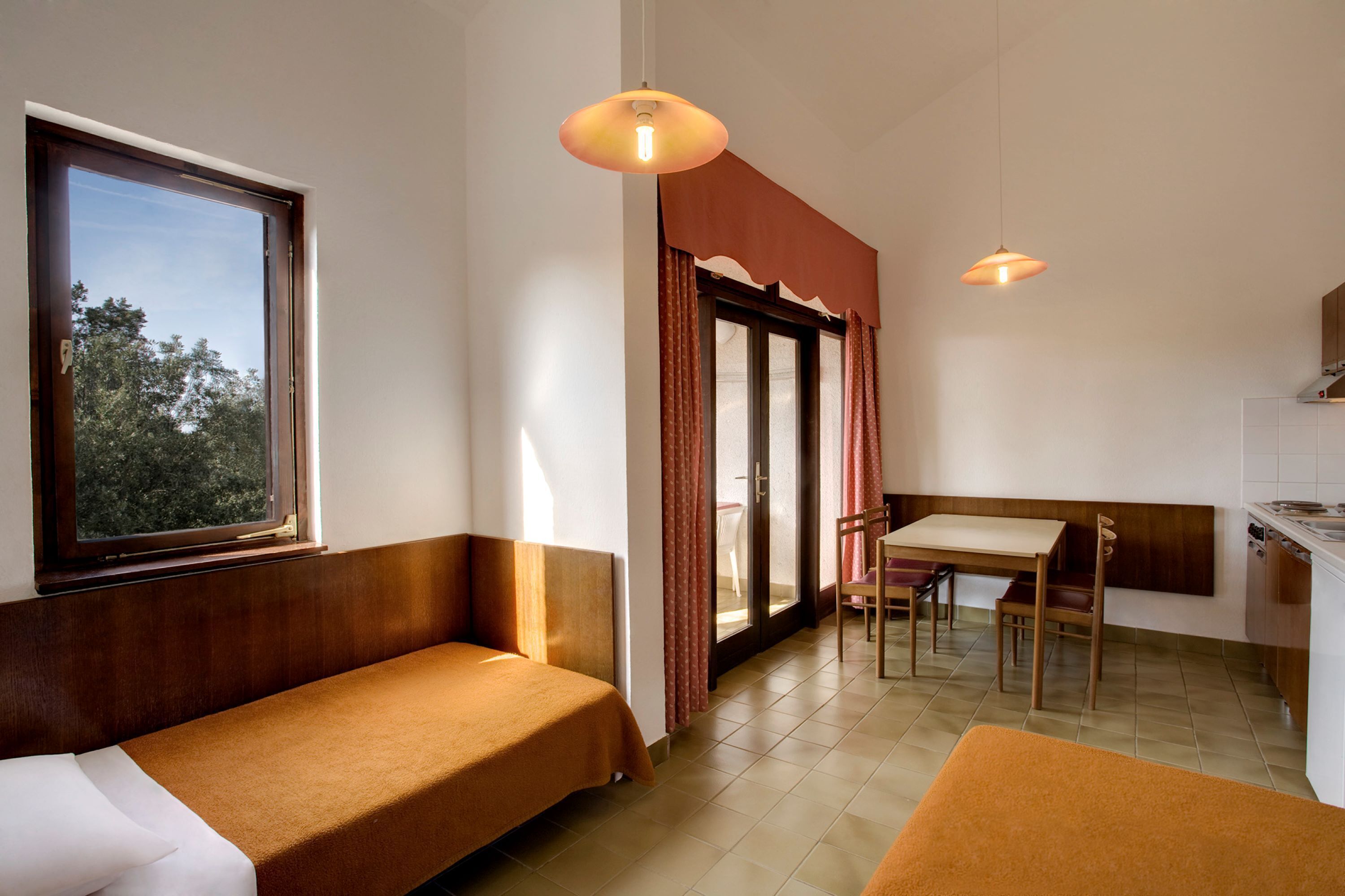 Une pièce de taille modeste comprenant un lit, une table à manger et un coin cuisine.