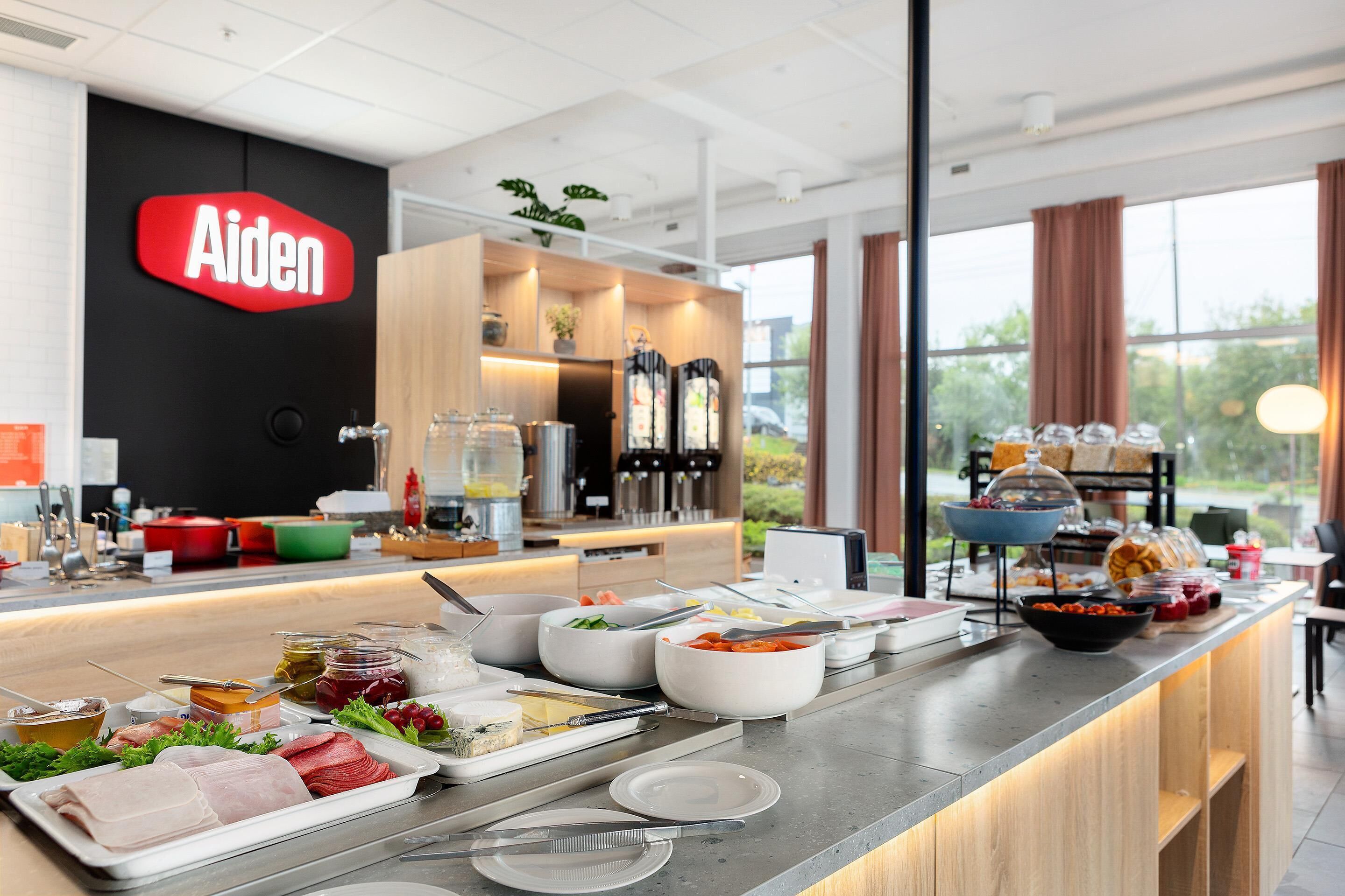 Montaje de bufé con diferentes alimentos y un letrero que dice 'Aiden' al fondo.