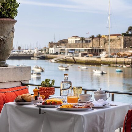 A table set with breakfast items overlooking a marina with boats and buildings.