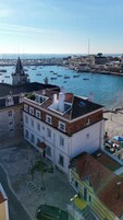 Un edificio con terraza en la azotea que da a un puerto con barcos.