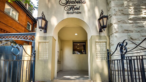 The entrance to Isabella Hotel Reception with a stone facade, arched doorway, and decorative lanterns. - Isabella Hotel and Suites (Toronto)
