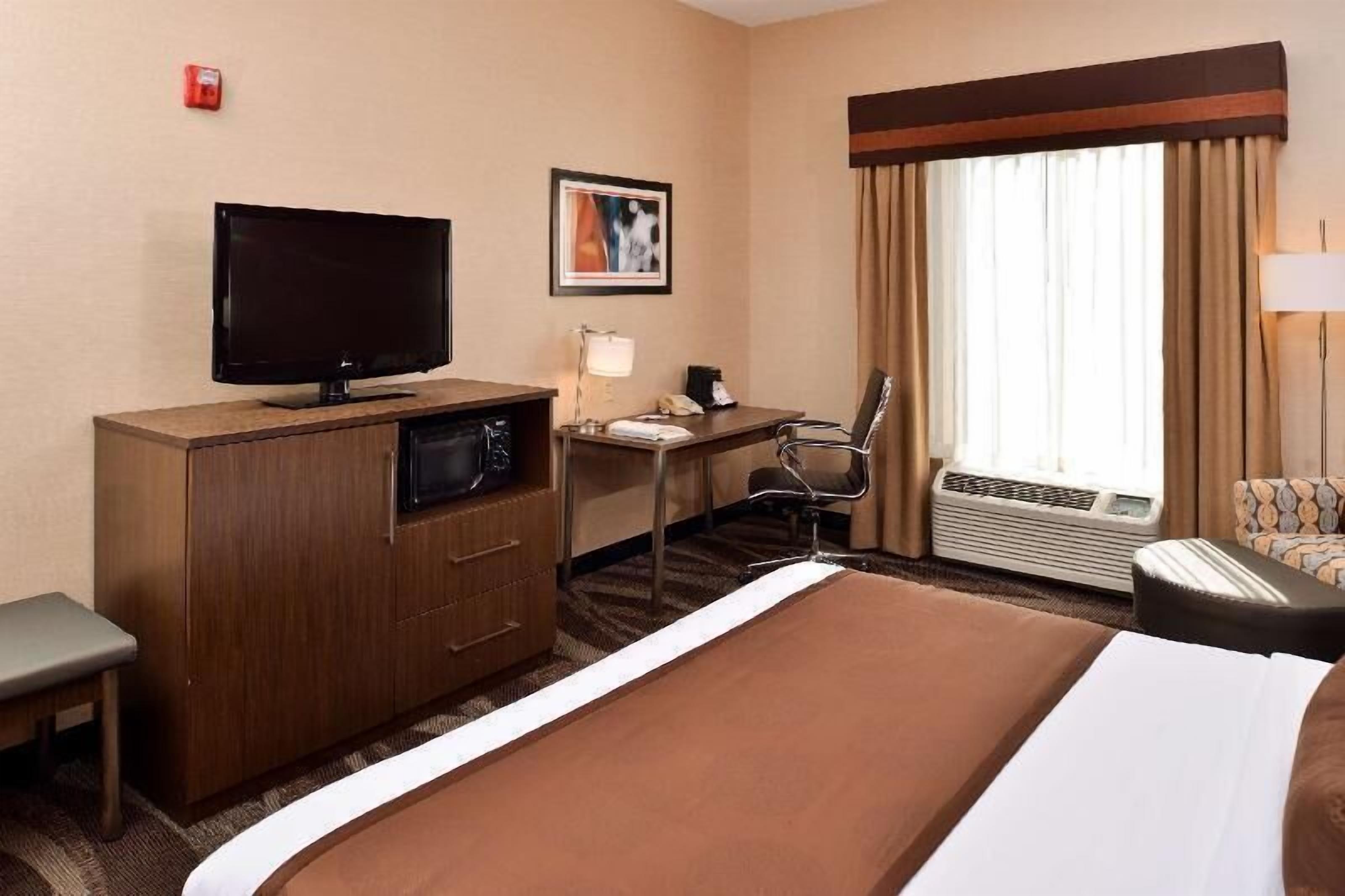 Premium bedding, desk, laptop workspace, blackout drapes