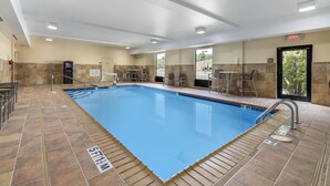A swimming pool with a tiled deck, a lifeguard chair, and a door marked "EXIT".