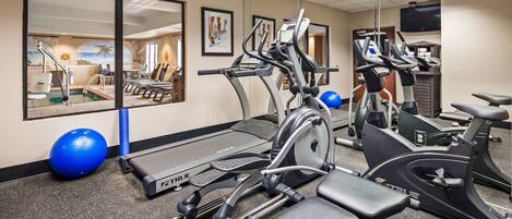 A gym with treadmills, ellipticals, and exercise balls.