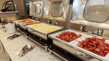 A buffet with various food options, including scrambled eggs, bacon, and other dishes.
