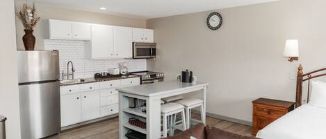 A compact living space with a kitchenette, a dining area, and a bedroom.