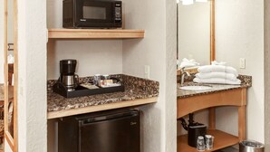 A compact kitchenette with a microwave, coffee maker, and refrigerator. - Aarchway Inn (Moab)