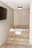 Un baño con bañera, ducha y retrete.
