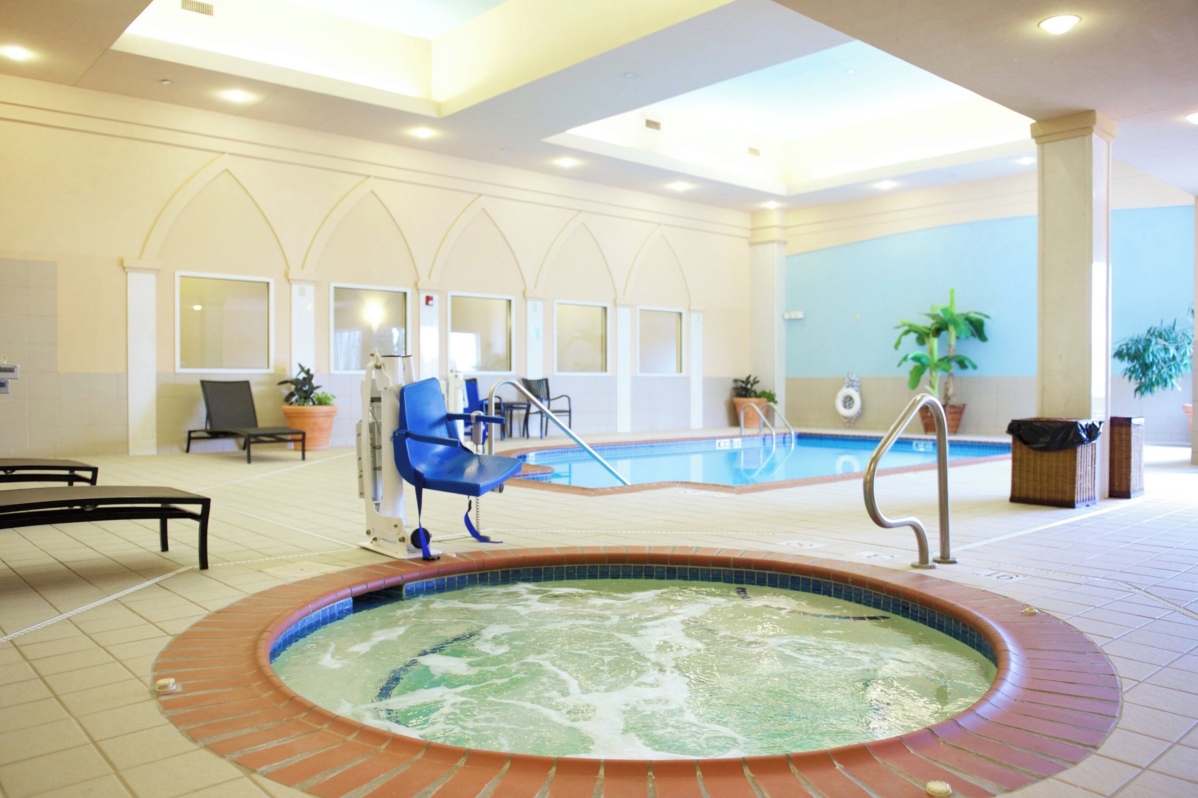 Un hall de hotel con piscina, zona de estar y bañera de hidromasaje.