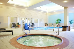 Un hall de hotel con piscina, zona de estar y bañera de hidromasaje.