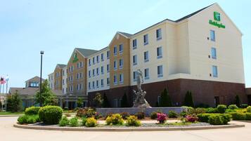 A Holiday Inn hotel with a central courtyard featuring a statue and landscaped gardens.