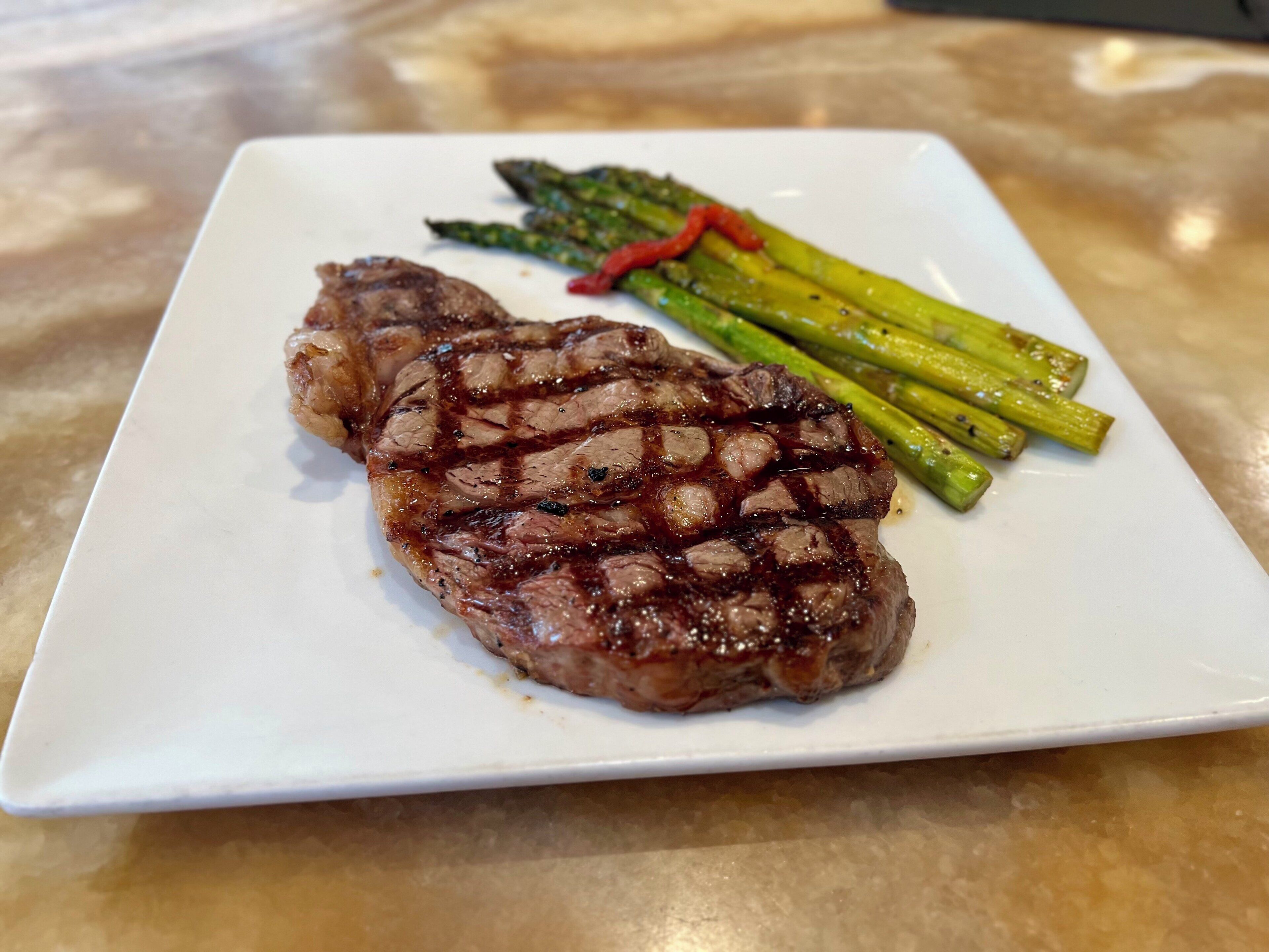 A plate with grilled steak and asparagus.