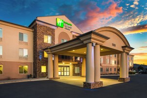 A Holiday Inn Express & Suites building with a stone facade and a covered entrance.