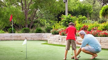 Enjoy a round of golf on this well-maintained course surrounded by lush greenery and vibrant flowers.