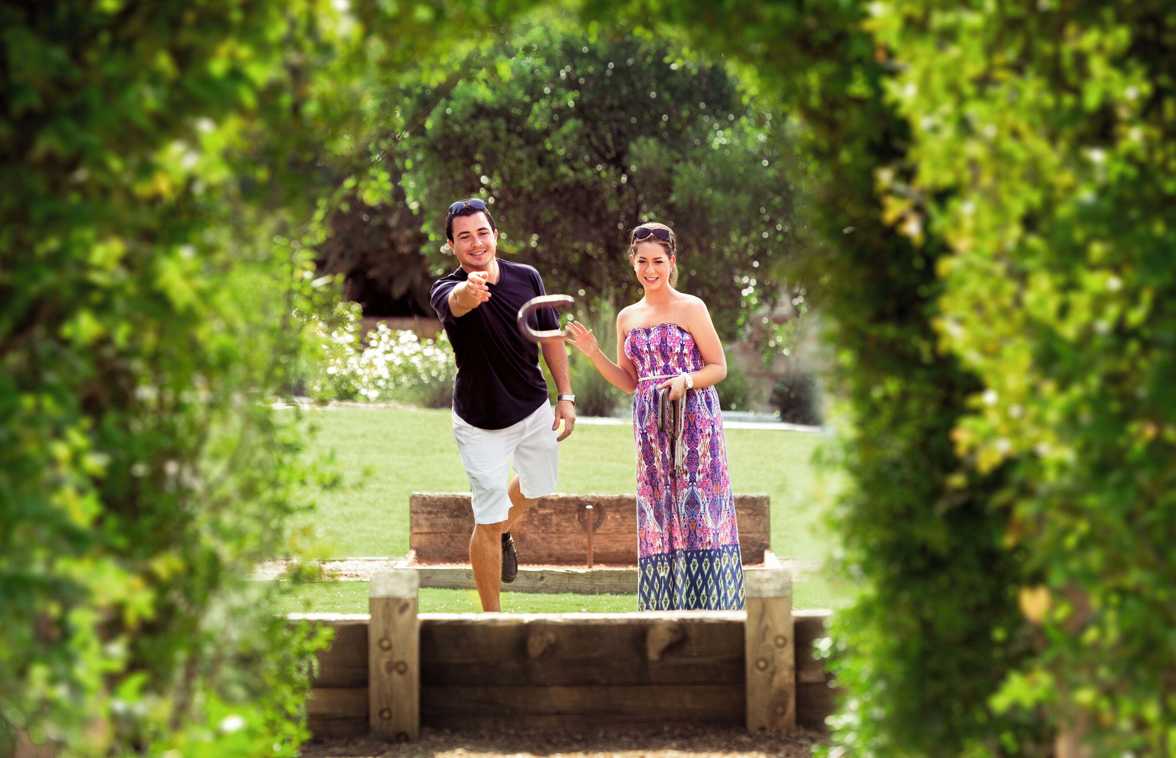 Un couple se tient sur une plateforme en bois, dans un parc entouré de verdure.