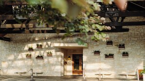 A stone building with a wooden door, potted plants, and a rope barrier. - Hyatt Vacation Club at Wild Oak Ranch, San Antonio (San Antonio)