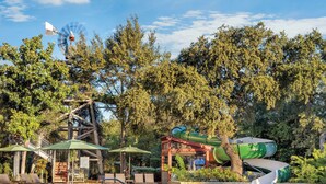 A pool area with a water slide, lounge chairs, and a windmill. - Hyatt Vacation Club at Wild Oak Ranch, San Antonio (San Antonio)