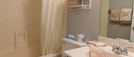 A bathroom with a bathtub, toilet, sink, and a towel rack.