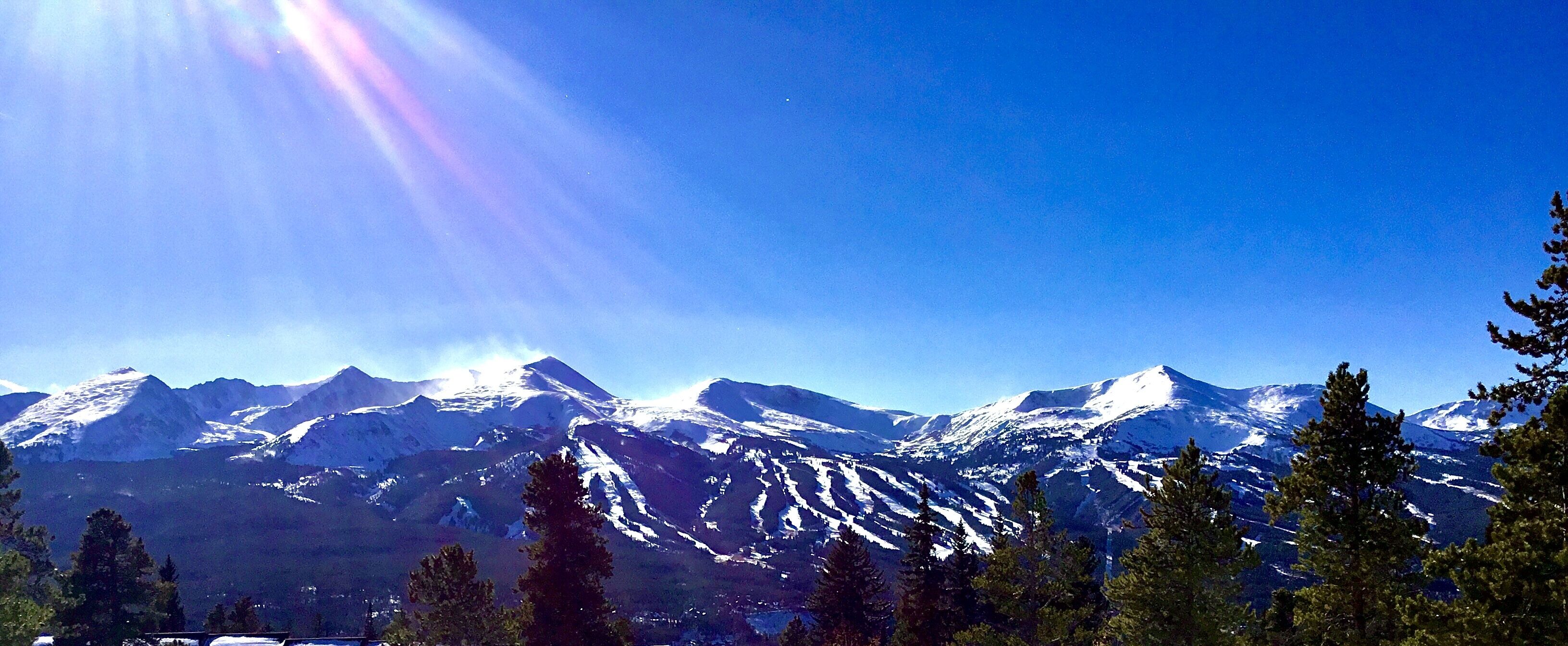 Una cordillera con picos nevados y un cielo azul despejado.