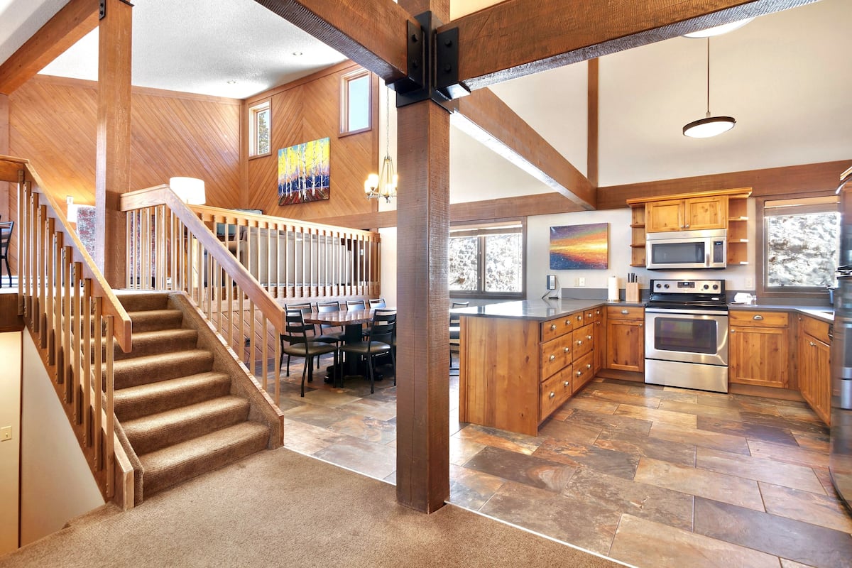 A spacious kitchen with wooden cabinetry, a large island, and a built-in oven.