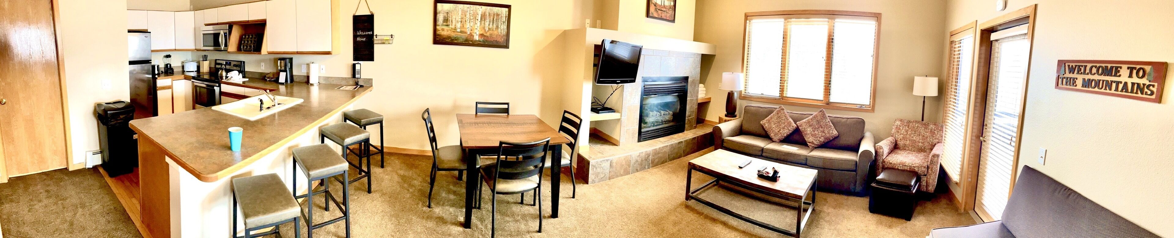 A compact living space with a kitchen, dining area, and a fireplace.