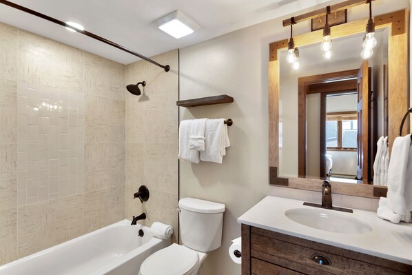 A modern bathroom with a bathtub, toilet, and sink. - Gold Point Resort Breckenridge by Vacatia (Breckenridge)