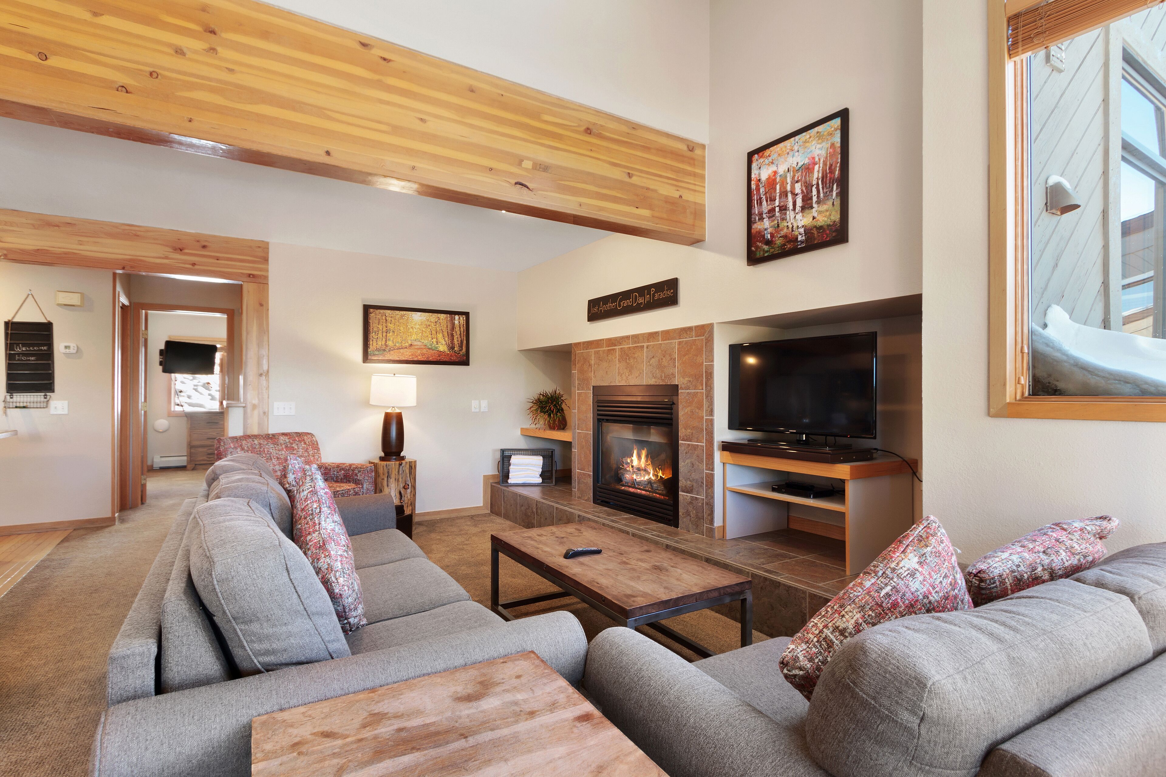 A modern living room with a fireplace, a television, and a sofa set.