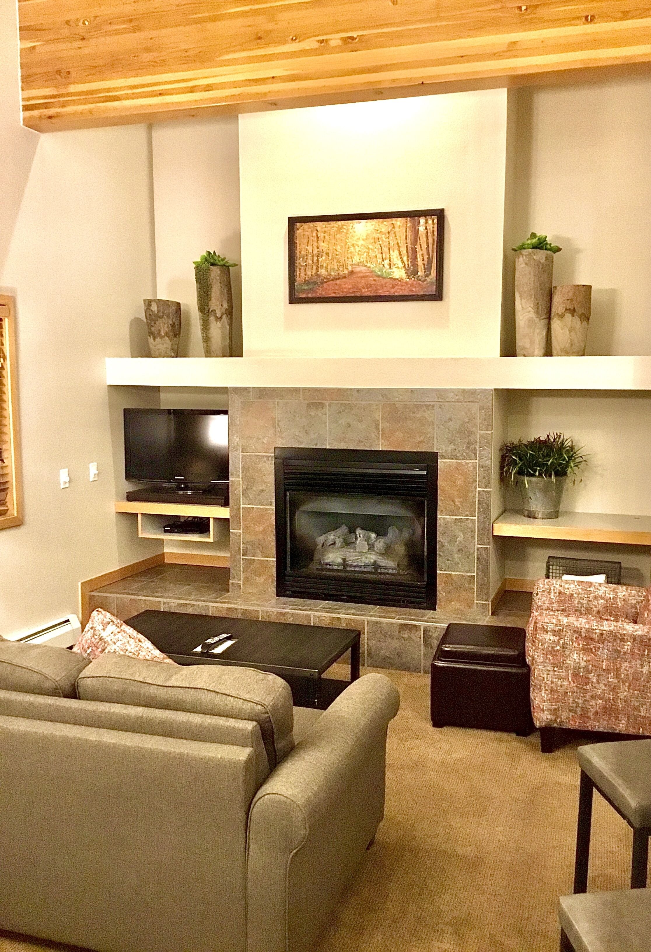 A living room with a fireplace, television, and seating area.