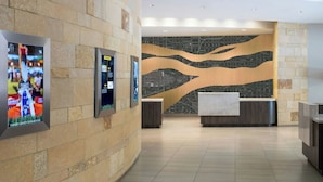 A lobby with stone walls, a reception desk, and informational displays.