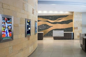 A lobby with stone walls, a reception desk, and informational displays. - Residence Inn by Marriott Washington, DC National Mall (Washington)
