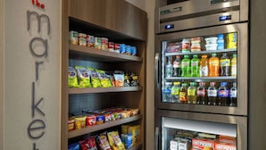 A grocery store with shelves stocked with snacks, beverages, and refrigerated items.