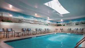 An indoor swimming pool with lounge chairs and a mural of a cityscape on the walls. - Residence Inn by Marriott Washington, DC National Mall (Washington)